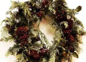 Lush evergreen wreath adorned with red berries and pinecones