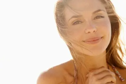 Woman with beautiful skin smiling. This is where Your Collagen Powder Actually Comes From (and Which type to Eat)