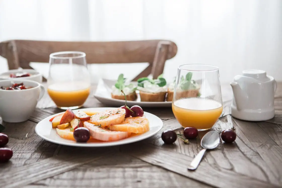 Table set with healthful foods and juice, adding collagen powder supplements to your morning beverage can benefit your joints.
