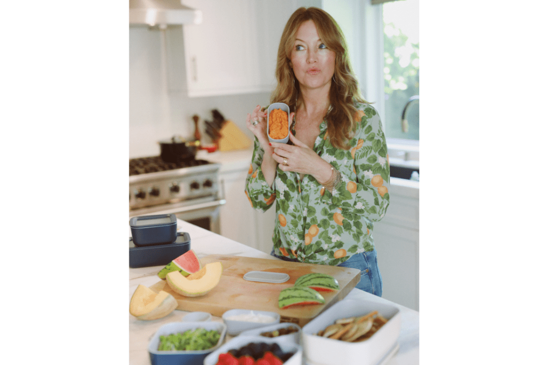 Image of Laura Klein, chef and editor-in-chief of Organic Authority, pictured in her own kitchen at her kitchen island with various food prep items stored in Caraway Home's food storage containers.