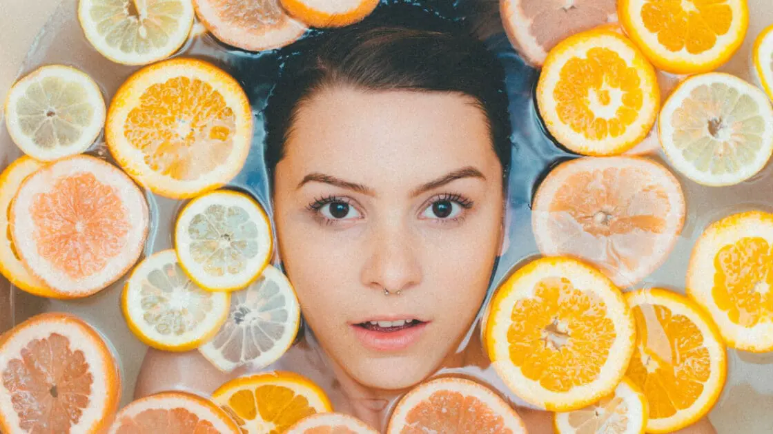 woman in tub surrounded by round citrus slices