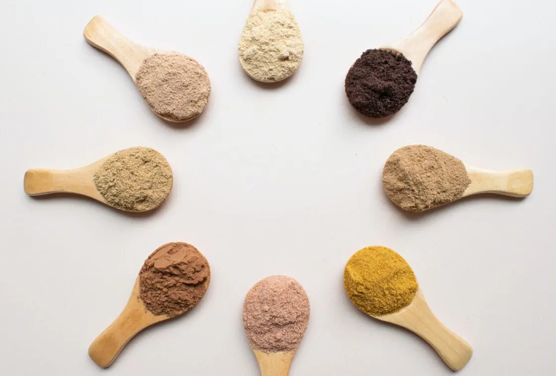 different colors of powders in wooden spoons representing collagen powder supplements that my help with wrinkles and sagging skin.