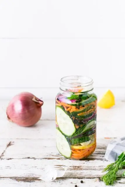 jar of fermented veggies, onion and lemon on table