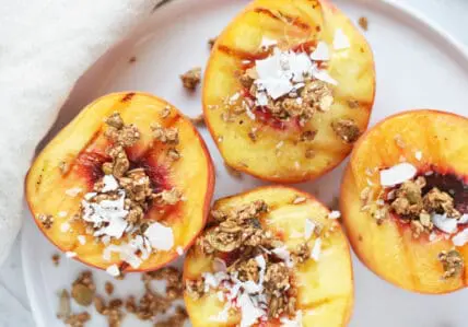 image of a grilled peaches recipe with granola and coconut flakes