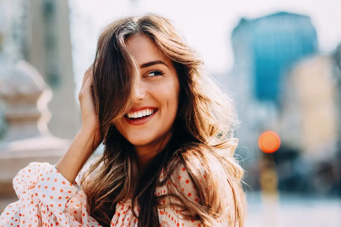 A smiling, healthy woman showing benefits of taking spirulina via Organic Authority