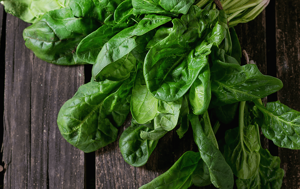 Spinach with twine on wood board