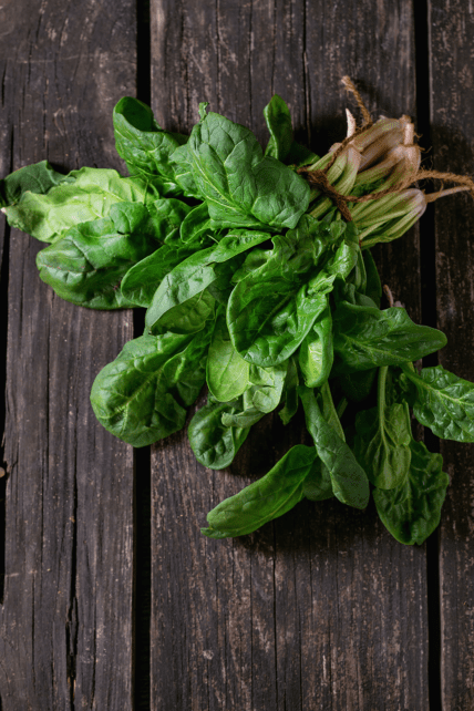 Spinach with twine on wood board