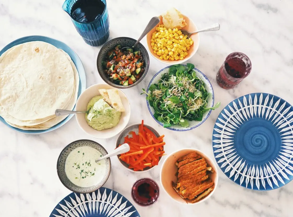Variety of foods on a marble table with blue pottery. Foods to consider for an elimination diet.