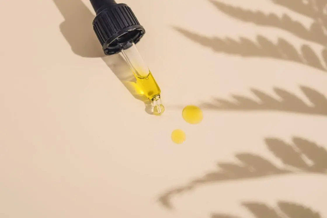 Image of Natural face serum oil in dropper on natural background with plant silhouettes via Organic Authority