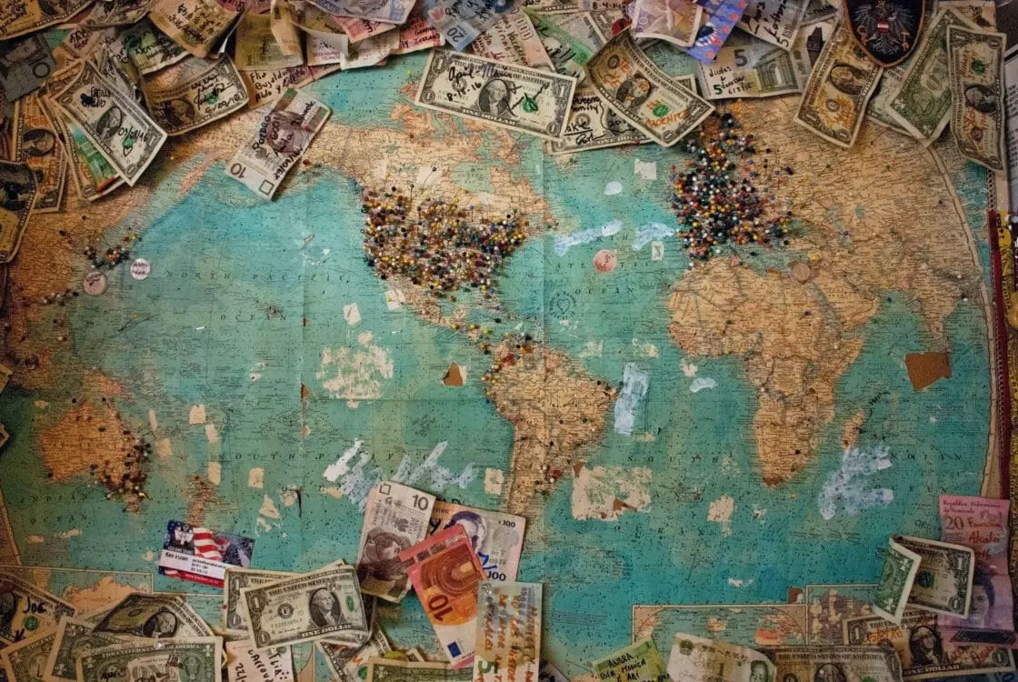 Image of a vision board featuring a map with pins and money pinned to it showing how to manifest your ideal future.