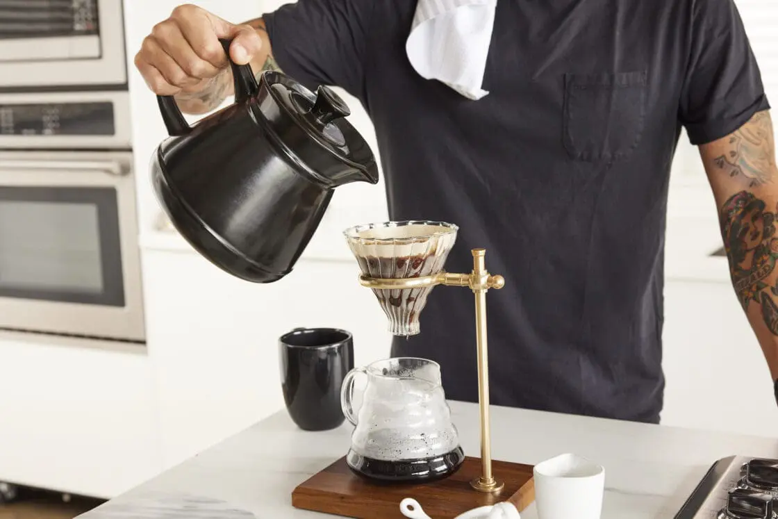 Image of Xtrema Cookware retro tea kettle set being used for pour over coffee by a man with tattoos. Which is way more stylish than just using a pot and more durable than you would expect considering that there are no metals. 