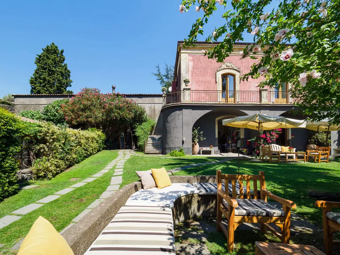 image of an Italian vacation villa with outdoor seating perfect for Italian wine tasting in the foreground.
