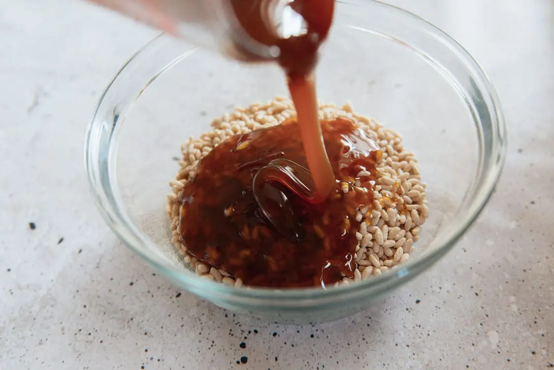 image of brown rice syrup being poured over brown rice cereal for the yummiest Halloween rice Krispie treats.