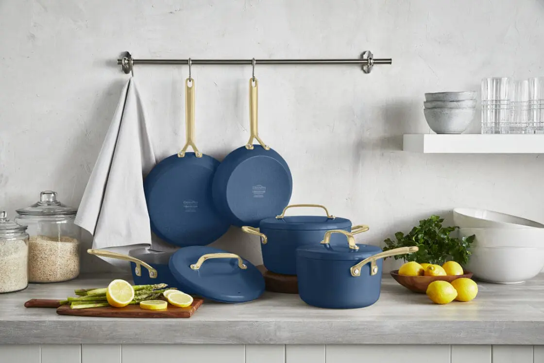 Image of the GreenPan GP5 15-piece ceramic cookware set in marine blue, displayed in a minimal kitchen, prepping a dish with lemons and asparagus.