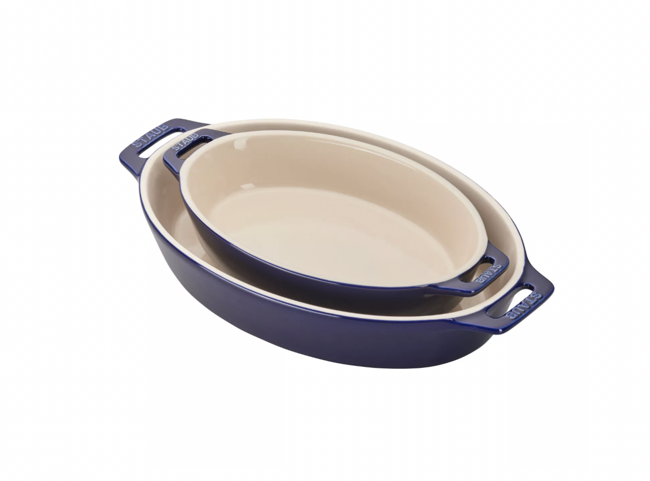 Image of the Staub Oval Baking Dish set in Navy, with the two dishes nested inside each other.