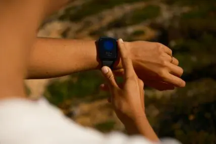 woman's wrist and hands checking her smartwatch during a workout