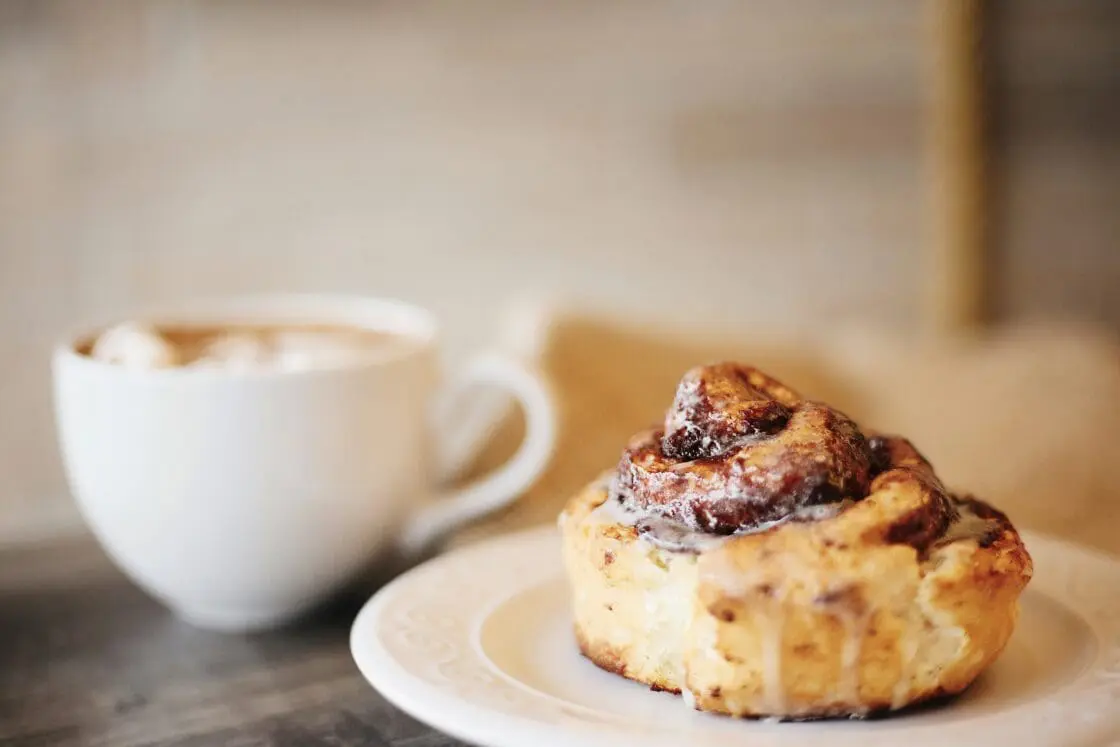 image of a vegan cinnamon roll recipe healthy with glaze and coffee