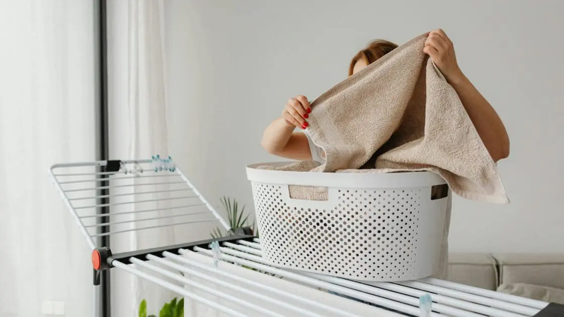 image of woman doing laundry with laundry basket using the best laundry products