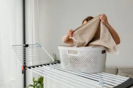 image of woman doing laundry with laundry basket using the best laundry products