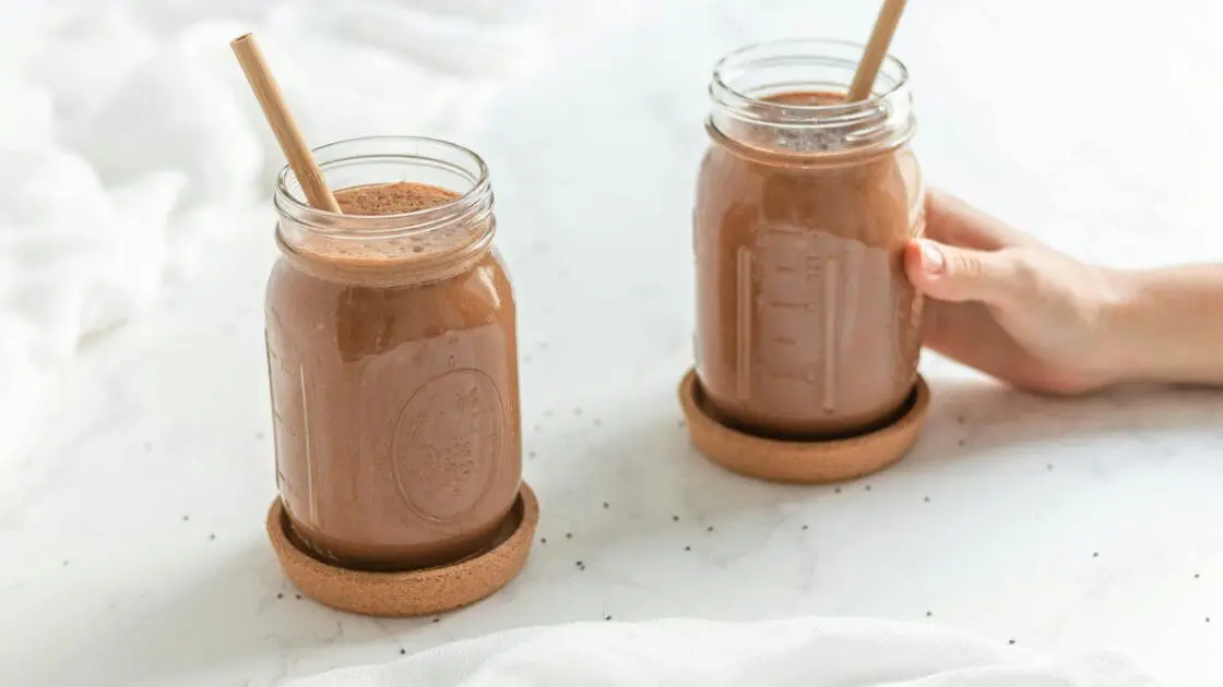 Image of a chocolate avocado smoothie with banana in two mason jars