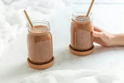 Image of a chocolate avocado smoothie with banana in two mason jars