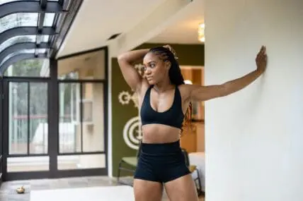 Image of a woman stretching because it's important to get in stretches when you can.