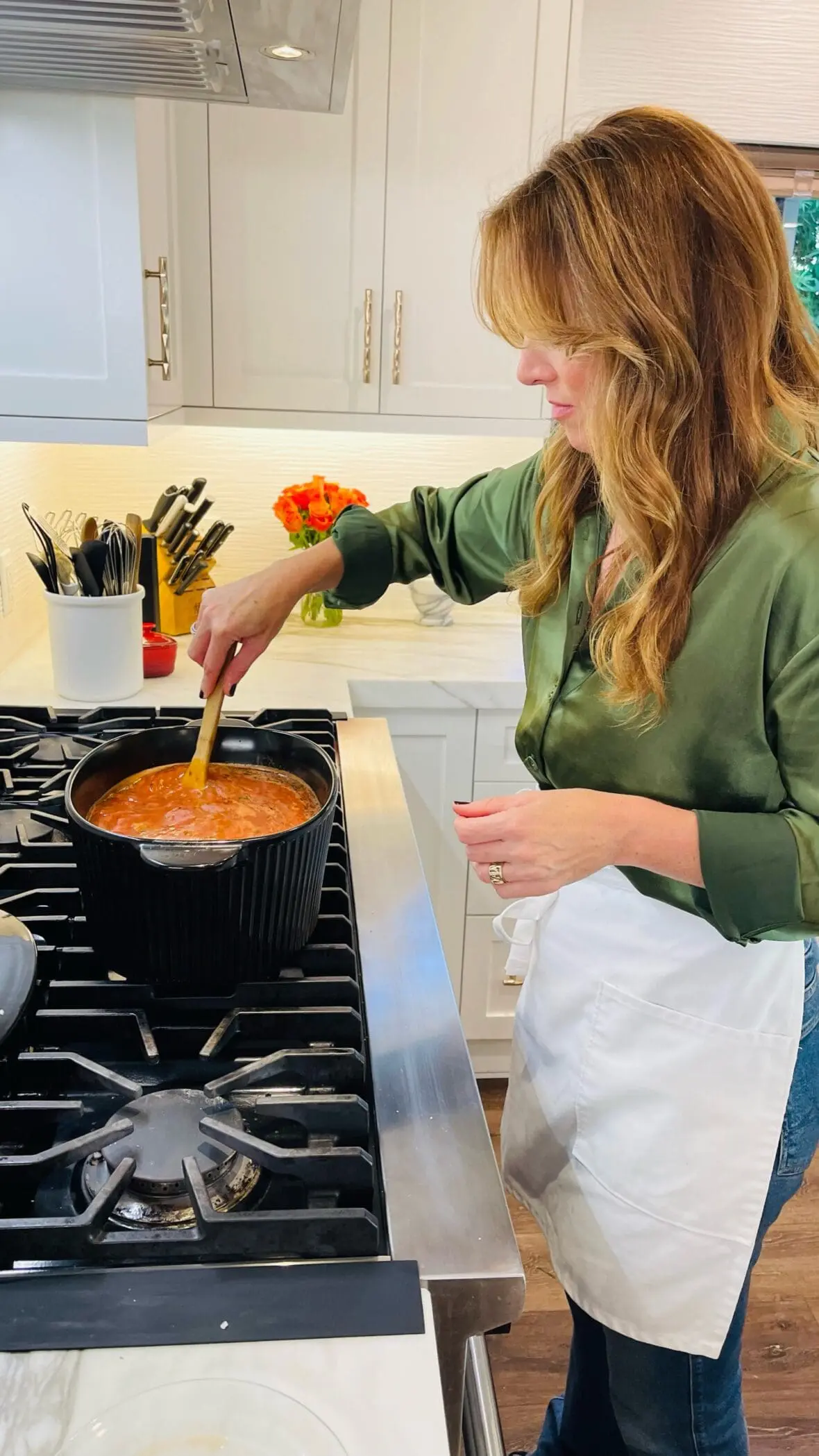 image of Laura Klein at her stove making one of the easiest lasagna soup recipes in what she considers the best ceramic cookware set, using a Dutch oven by Xtrema