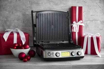 The best GreenPan small electric appliances wrapped as gifts in red paper with white ribbon, with the Premiere Multi Grill, Griddle & Waffle Maker on display front and center.