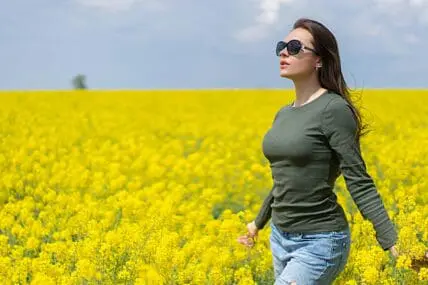 woman in field of yellow flowers for natural menopause remedies