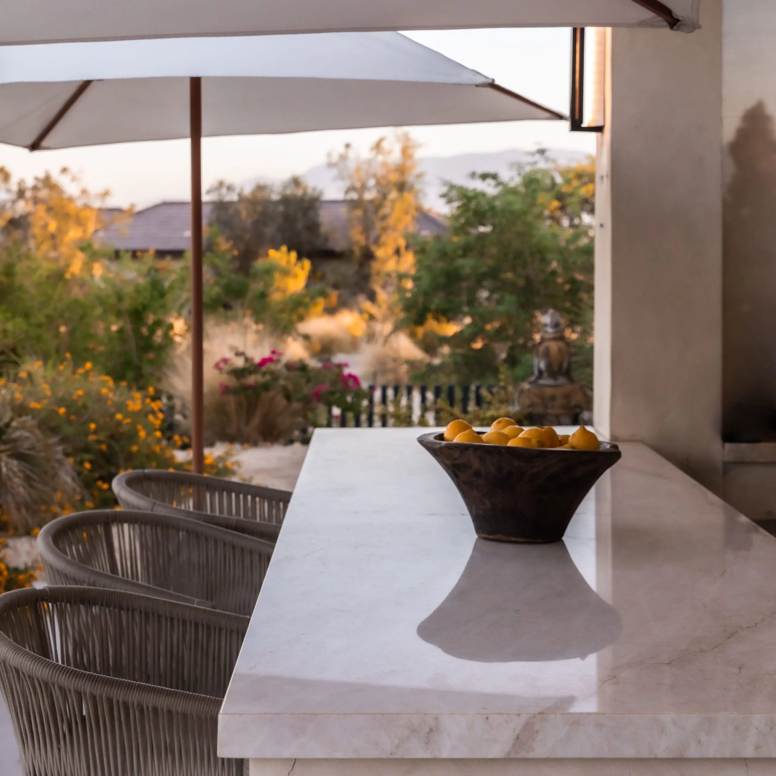 Image of a solid marble bar with a large bowl of fruit outside with beautiful desert shrubbery in the background at a retreat that specializes in the benefits of colonics.