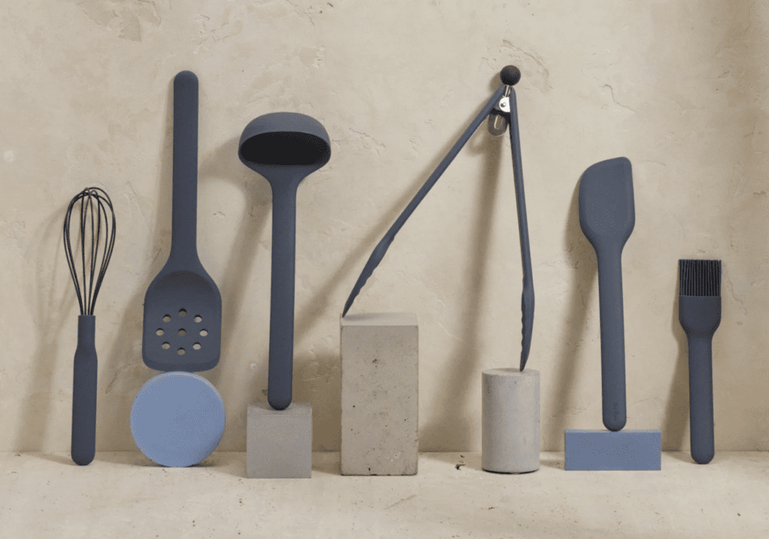 Image of the six-piece set of Our Place silicone cooking utensils, arranged against a marble wall and ceramic props.