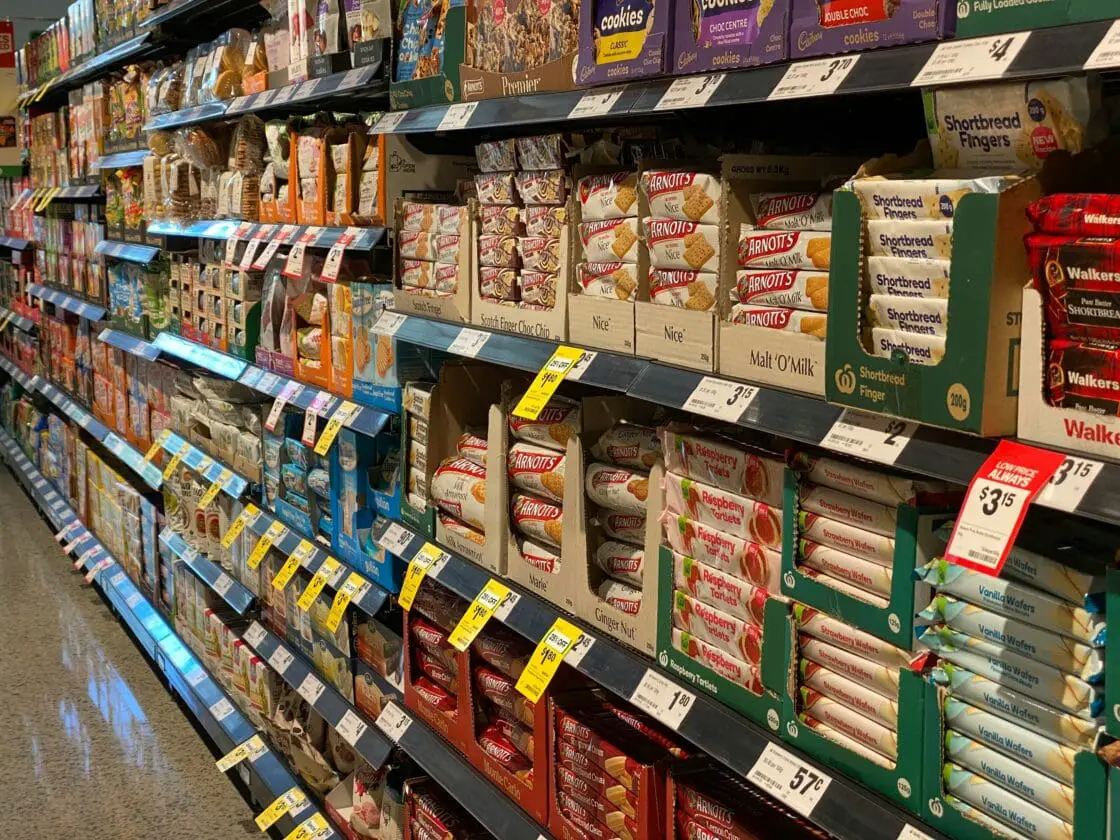 Image of a supermarket aisle stocked up with all sorts of ultra-processed foods that wouldn't be a part of the best diet for brain health, from chips to packaged cookies.