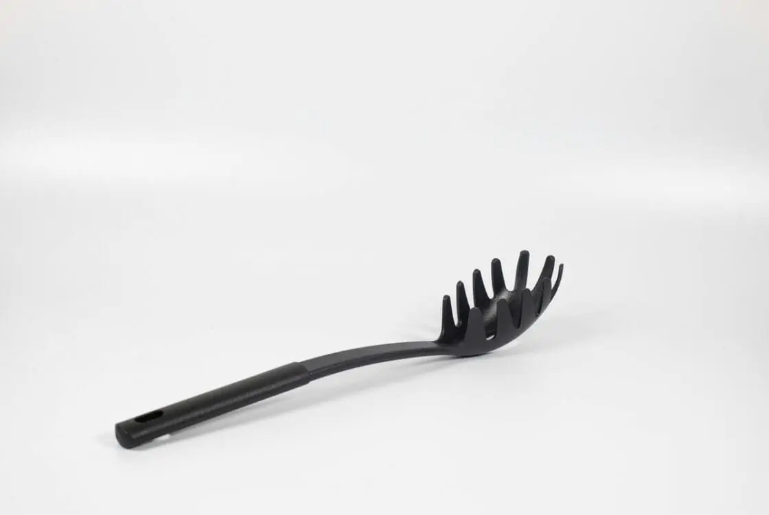 Image of a black plastic spoonula laid flat on a white background.