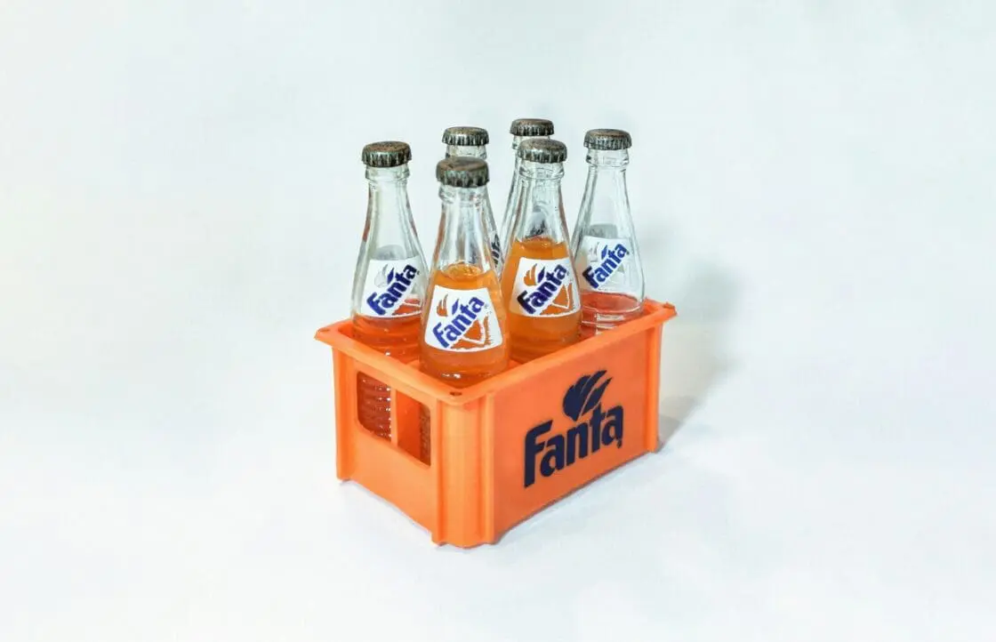Image of an orange plastic carton holding six glass bottles of Fanta, which the sugary drink tax would make more expensive to discourage consumption.