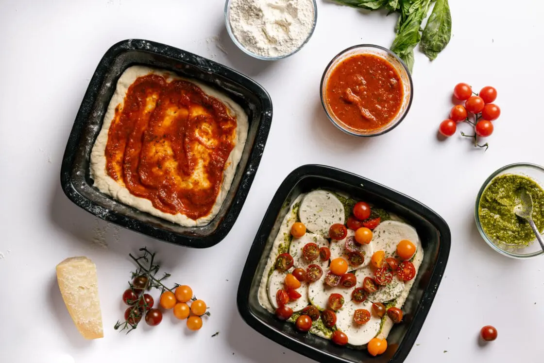 Image of Xtrema pure ceramic PFAS free cookware, two square bakers with layers of tomato sauce, cheese, and tomatoes.