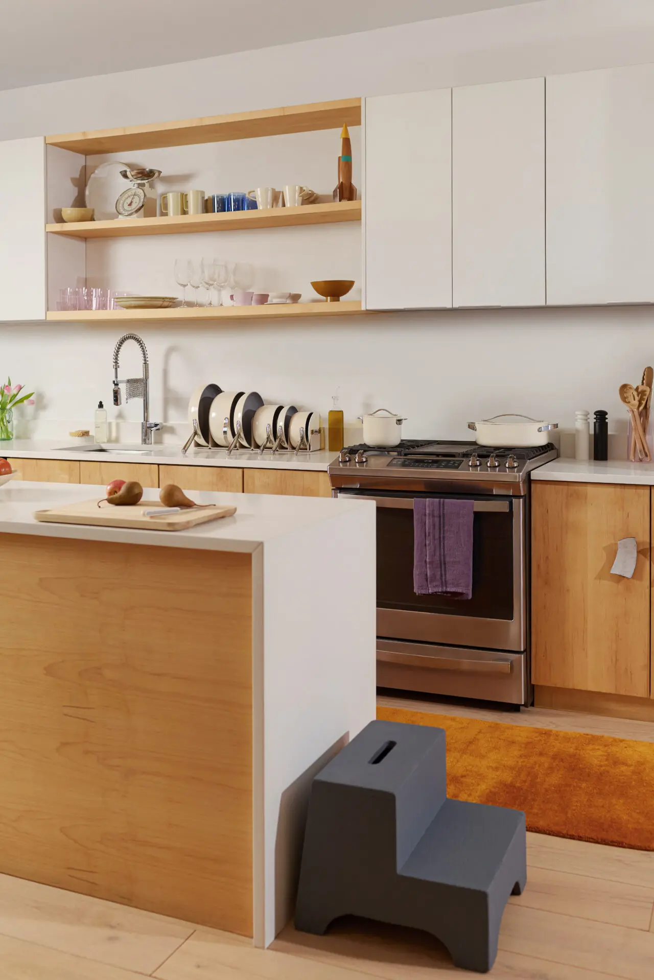 image of the ultimate in mothers day gifts, the Caraway Mother's Day Bundle Signature Ceramic Collection, all stacked neatly in the organizers on a kitchen counter alongside a stove.