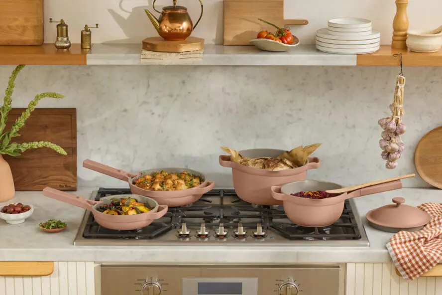 Image of several Our Place cookware pieces in the color Spice, shown in a brightly lit kitchen.