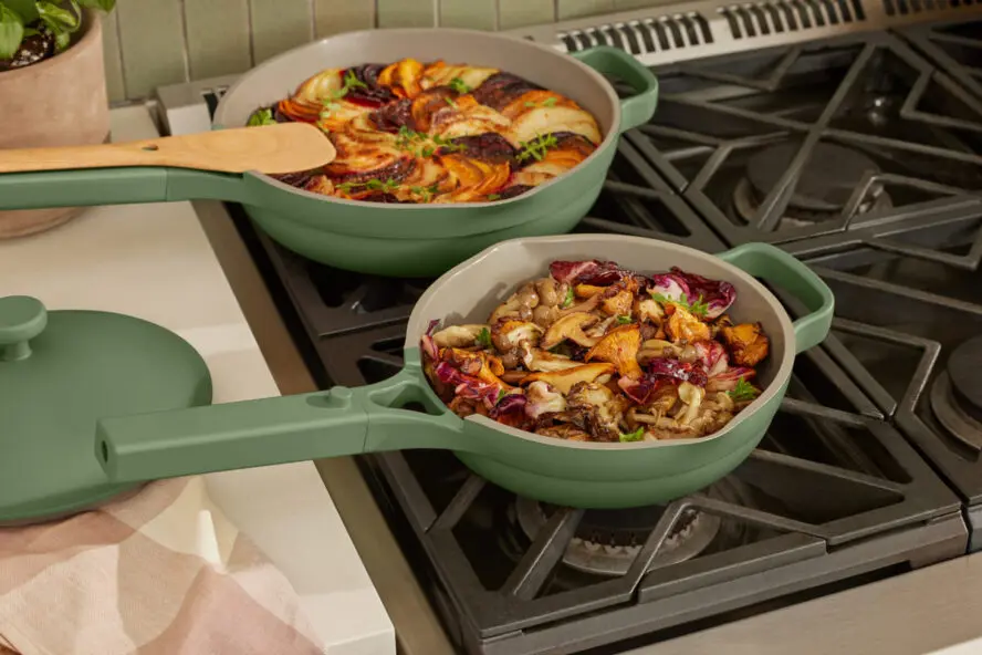 Image of two Our Place Always Pans in a large and mini size, both in a green color shown used to cook beautiful meals on a stovetop.