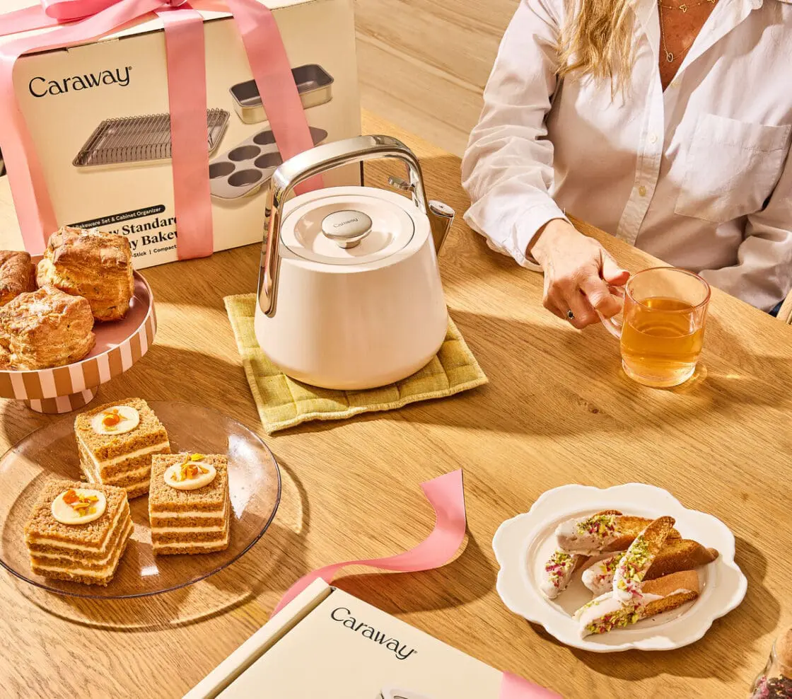 Image of several new Caraway products in packages or on display in a cozy kitchen with treats on plates around them.