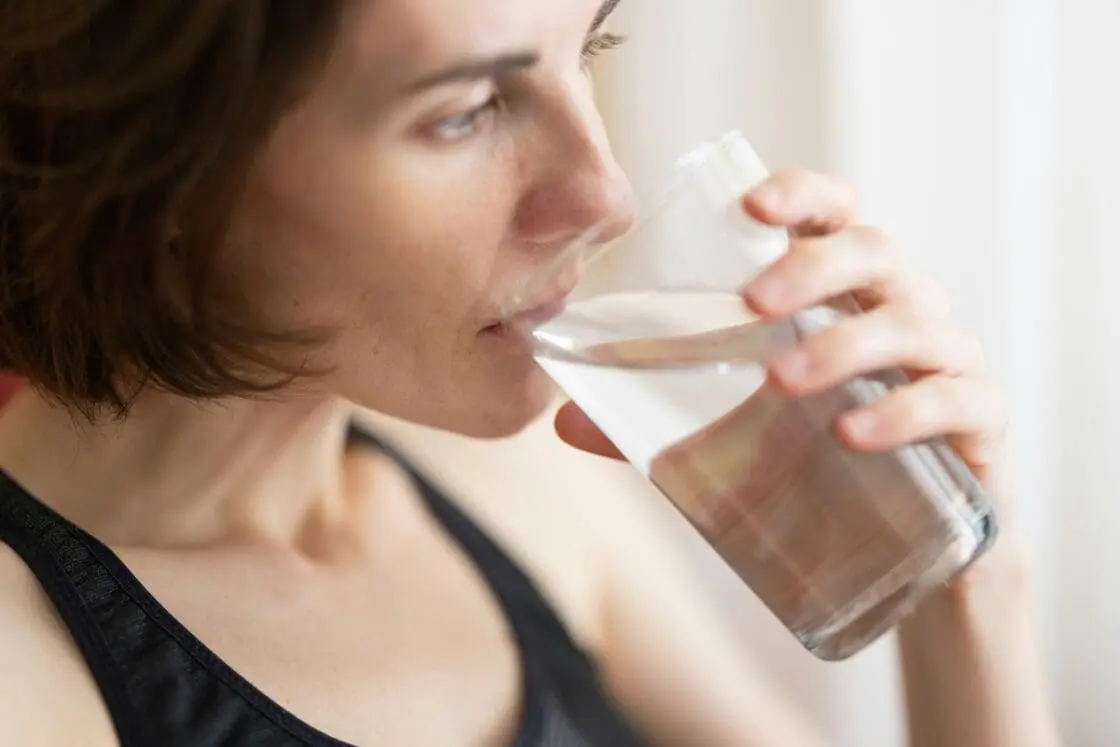 Image of a woman taking a sip of water from a glass.