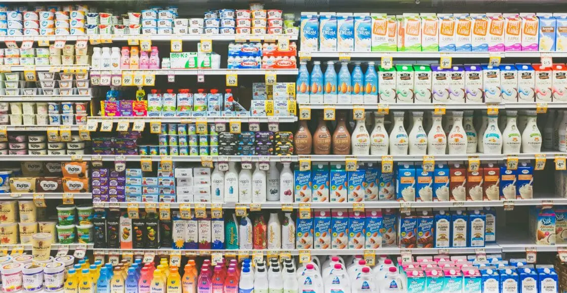 Image of the dairy section of the grocery store with a mix of plant-based milks and dairy products.