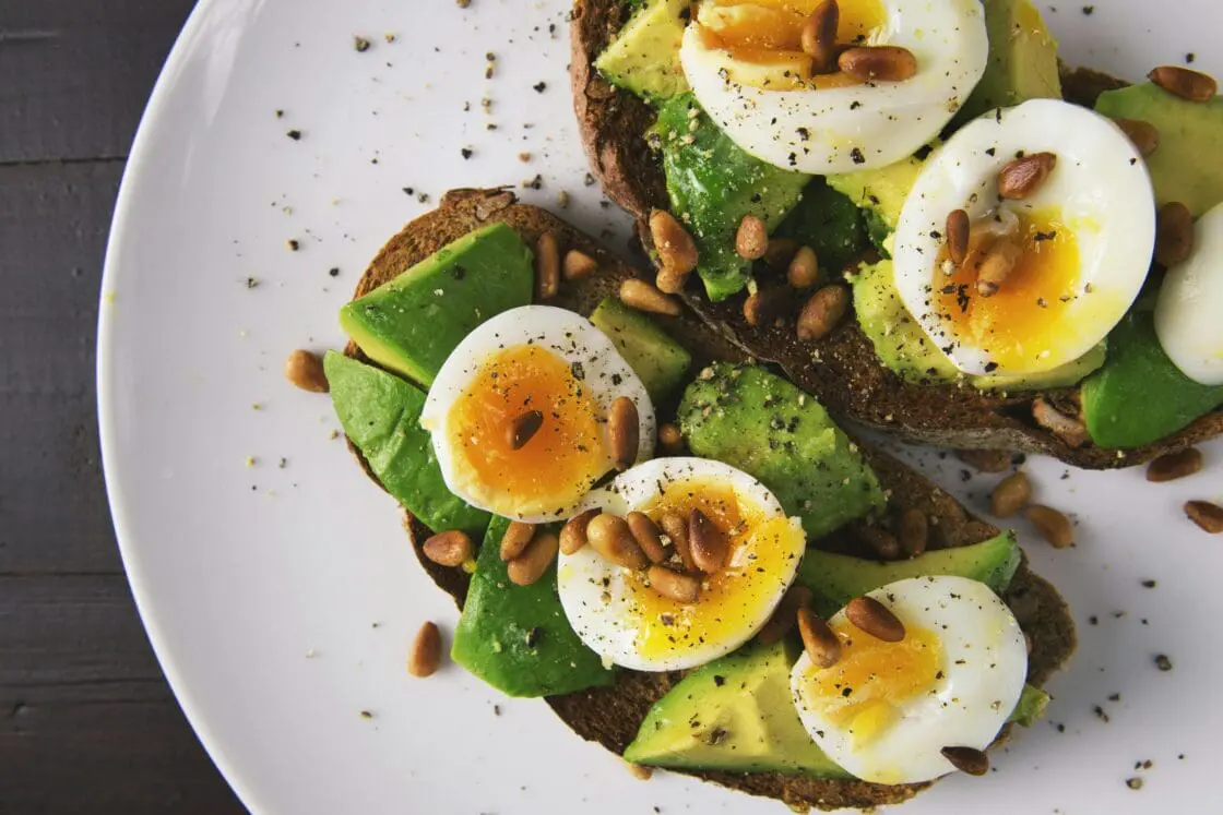 Image of a plate of avocado toast with sliced boiled eggs on top. This avocado recipe is on of the most popular ways to enjoy avocados.