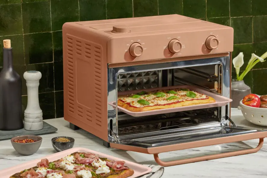Image of an Our Place Wonder Oven and air fryer and more with a pizza inside.