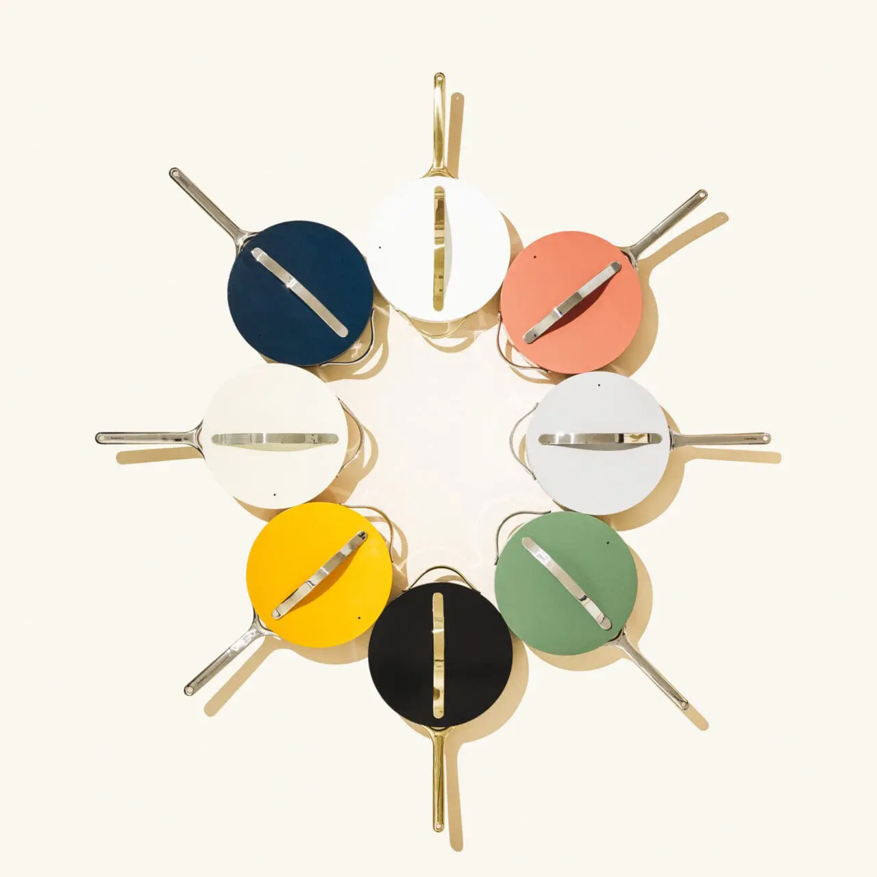Image of caraway cookware from above with ceramic coated lids on in different colors making a starburst design. 
