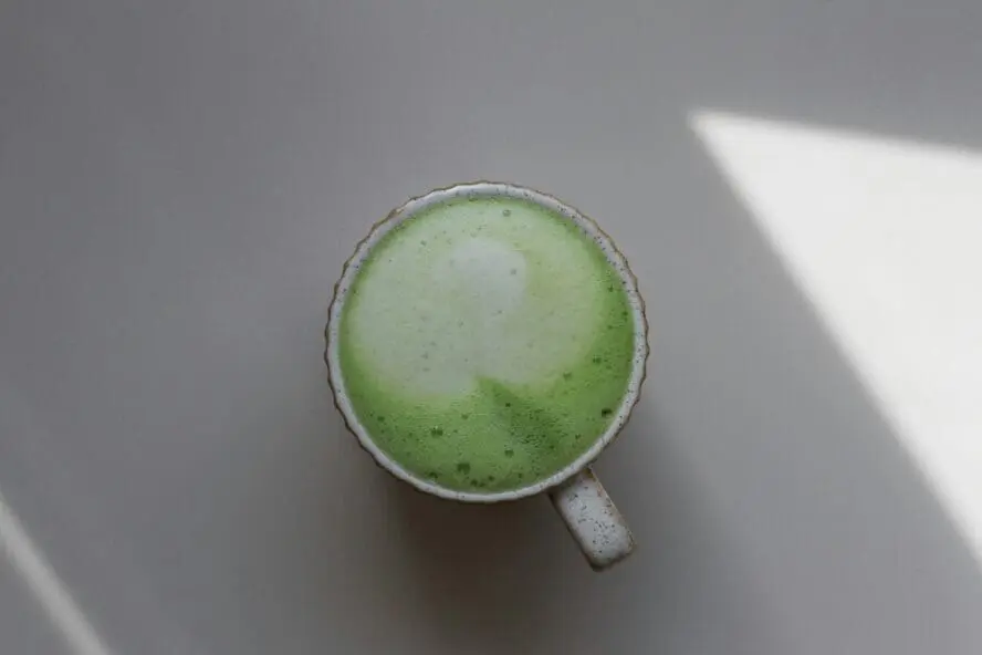 Image of a cup of matcha green tea latte set on a table.