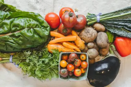 abundance of fresh fiber-rich vegetables including carrots, potatoes, and tomatoes.