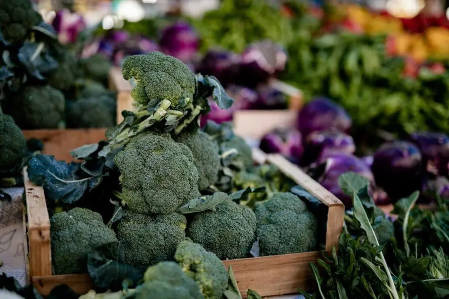 Image of piles of broccoli at the farmer's market on a table.