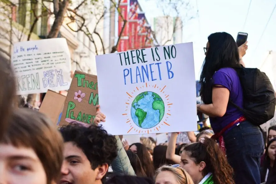 Image of a crowd at a protest, with someone holding a sign up that reads "There Is No Planet B".