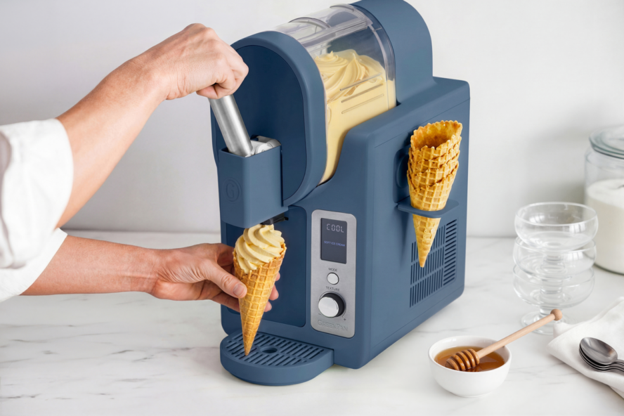 Image of the GreenPan Frost Pro in navy being used to make creamy honey frozen yogurt shown poured into a waffle cone.