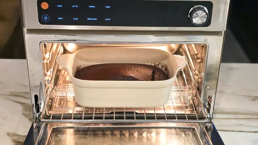 Image of the Our Place Wonder Oven Pro in stainless steel being used to bake a pan of chocolate bread.
